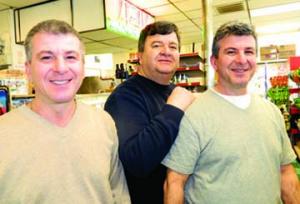 Ashmont Market: Peter, Harry, and John Georgoulopolous have worked side by side since 1984. The brothers sold the business to a new family on Monday, but plan to work there in the near term to help with the transition. Photo by Bill Forry