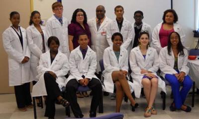 Medical Scholars on Bowdoin Street: Dr. Alphonso Brown, top row at center, is pictured with the 11 graduates of his inaugural Medical Scholars Program, ICAN, during a ceremony at the Bowdoin Street Health Center last Saturday, June 9. Photo by Sharon Ng