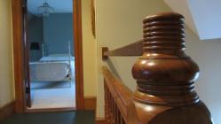 A lighthouse-inspired newel post outside a top-floor bedroom