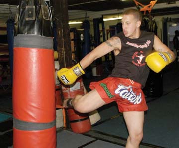 Kickboxing in Uphams: Colin Dwyer, a native of Adams Corner, worked the heavy bag at Boston Muay Thai Academy on Monday. Photo by Mike Deehan