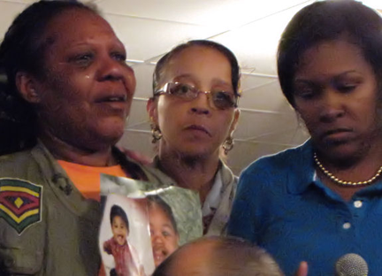 Mourning toddler: The grandmother of Amanihotp Smith,2, held up photos of the little boy at Morningstar Baptist Church. Photo by Adam Gaffin/Universal Hub