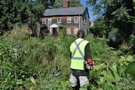 Worker clears brush on Fowler-Clark property