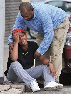 Chris Byner, who heads the city's Streetworker program, comforts grieving woman