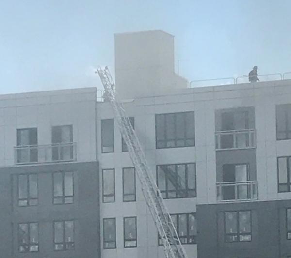 The first minutes of the June 28 fire on the top floor and roof of the Treadmark building were captured in this photo, which shows a firefighter on the roof. Polly O'Brien photo