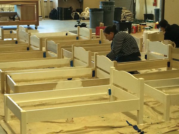 A volunteer helped to sand down recently built toddler beds at the New England R